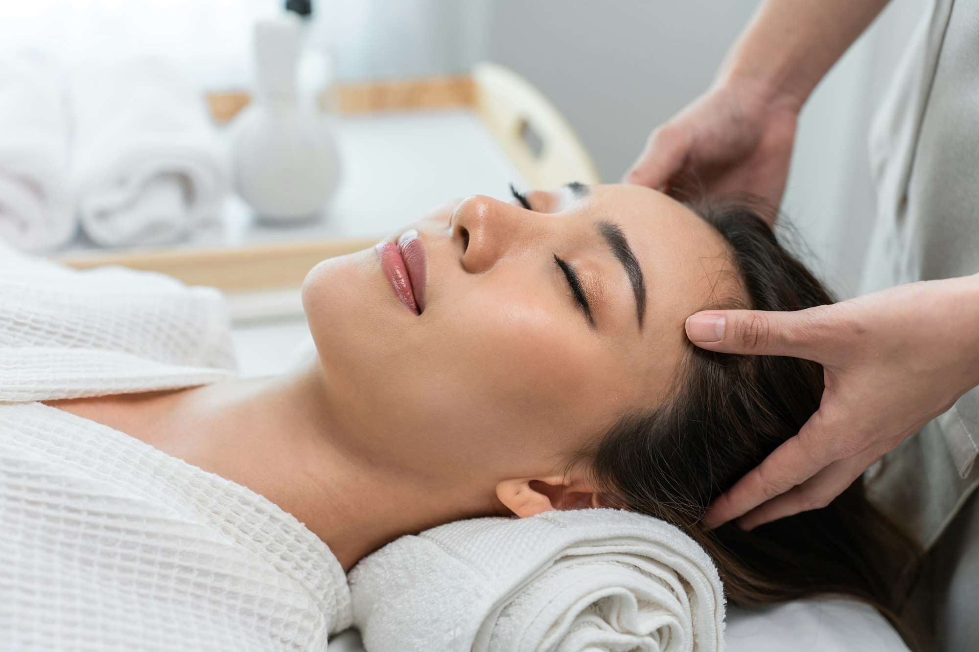 Asian young woman feel happy and relax during facial and head massage.