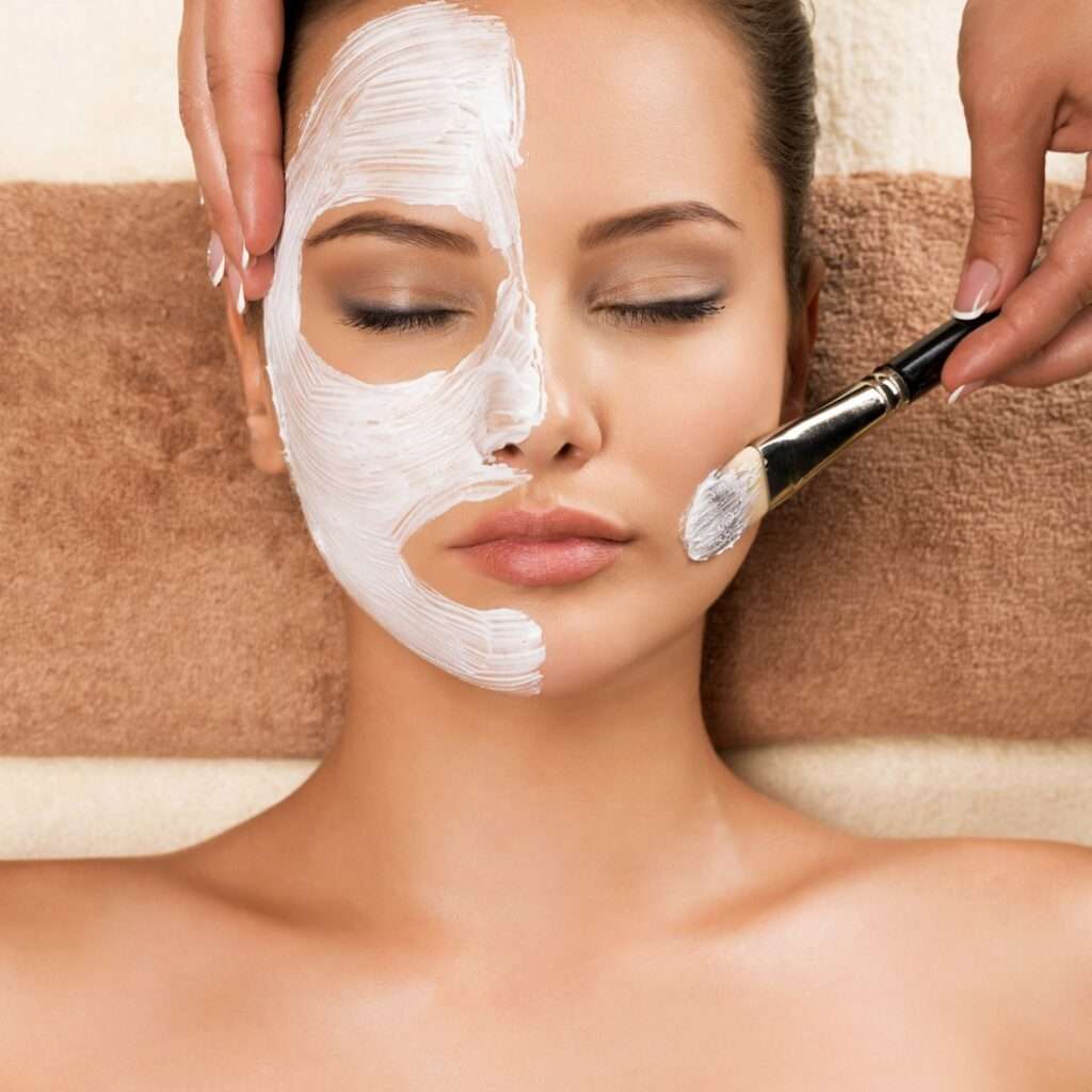 Woman having a facial cosmetic mask at spa salon.